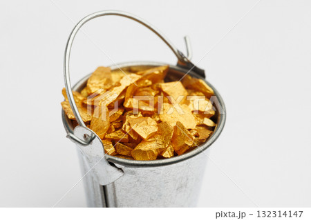 Small metal bucket filled with golden stones on white background. Concept of wealth Small metal bucket filled with golden stones on white background. Concept of wealth 132314147