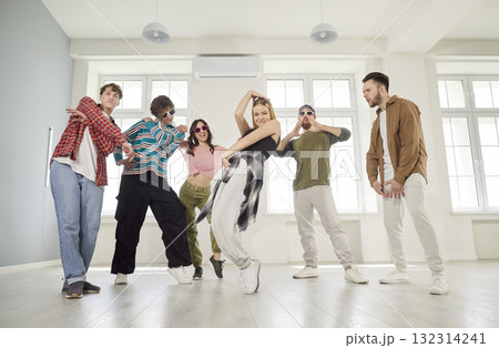 Young energetic people dancing together in modern dance studio 132314241