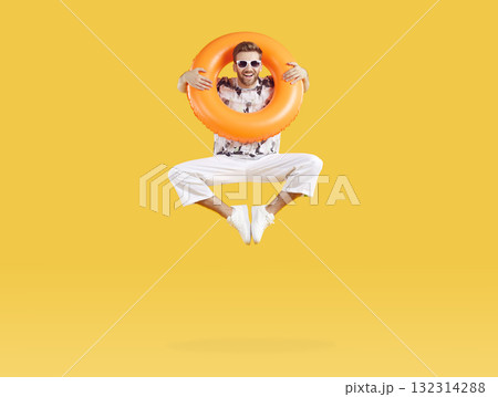 Smiling happy man jumping with inflatable rubber ring 132314288