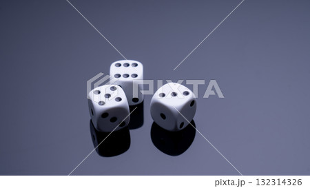 Three white dice are on a dark surface Three white dice are on a dark surface 132314326