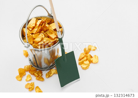 Small metal bucket filled with golden stones on white background. Concept of wealth Small metal bucket filled with golden stones on white background. Concept of wealth 132314673