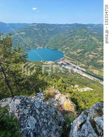 Scenic aerial view of hydroelectric dam on turquoise lake surrounded by lush green forest Scenic aerial view of hydroelectric dam on turquoise lake surrounded by lush green forest 132314710