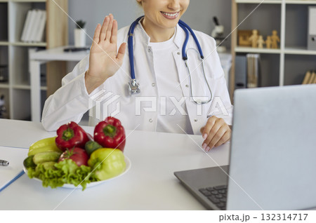 Online dietitian consultation from medical office with laptop and fresh produce Online dietitian consultation from medical office with laptop and fresh produce 132314717