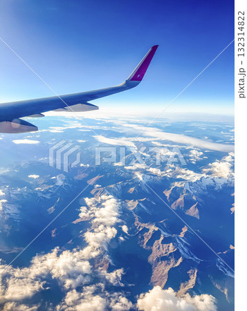 View from Airplane Window Wing and Mountains under Blue Sky View from Airplane Window Wing and Mountains under Blue Sky 132314822