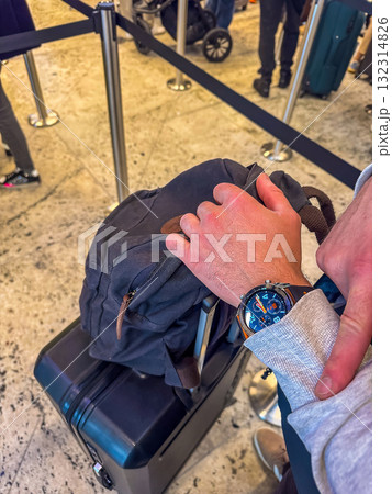 Traveler Checking Time on Watch While Waiting at Airport Queue Traveler Checking Time on Watch While Waiting at Airport Queue 132314826