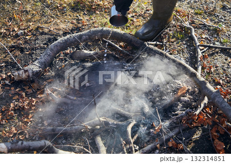 Extinguishing a fire with a cup of water Extinguishing a fire with a cup of water 132314851