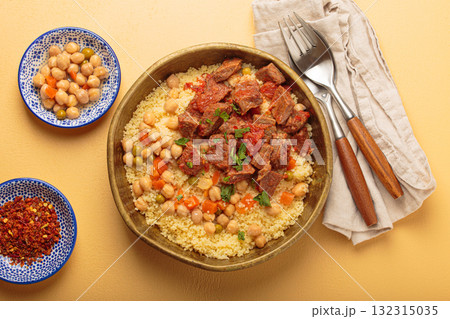 Moroccan couscous with tender meat and chickpea stew in rustic bow top view, Maghreb cuisine 132315035