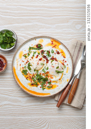 Turkish eggs cilbir, Middle Eastern style breakfast on white wooden background table top view 132315036