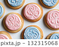 Colorful gender reveal cookies are artistically arranged in a flat-lay, featuring intricate designs in pink and blue icing. The soft lighting enhances the delightful treats 132315068