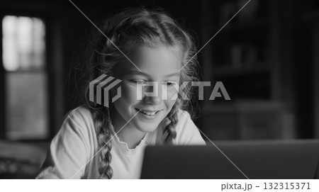 At home, a smiling girl is seated with her computer At home, a smiling girl is seated with her computer 132315371