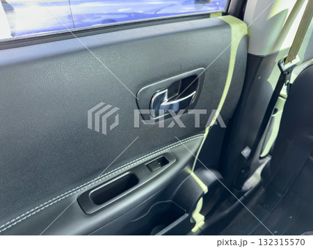 Close-up view of a car door handle and interior panel in a modern vehicle capturing details of the design and finish Close-up view of a car door handle and interior panel in a modern vehicle capturing details of the design and finish 132315570