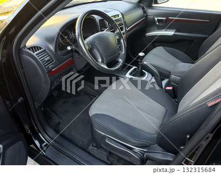 Interior view of a sleek car showcasing modern design, comfortable seating, and a sophisticated dashboard in bright daylight 132315684