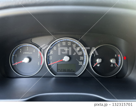 Dashboard view of a vehicle showing speed, RPM, and fuel level during a daytime drive 132315701