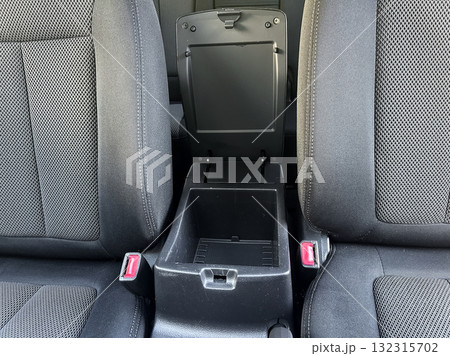 Comfortable car interior featuring sleek black fabric seats with a center console for storage and convenience during road trips 132315702