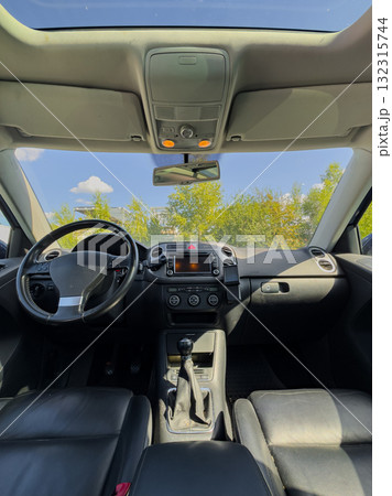 Inside a modern vehicle showing sleek interior design and clear blue sky, sunlight streaming through windows on a peaceful day 132315744
