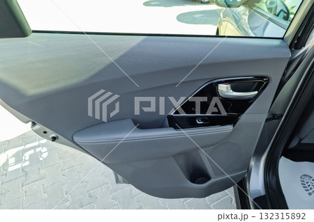 Sleek interior of a modern car showing the door panel and controls on a bright day at a dealership Sleek interior of a modern car showing the door panel and controls on a bright day at a dealership 132315892