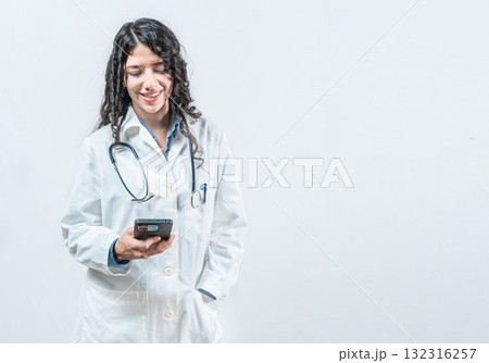Smiling female doctor using smart phone isolated. Doctor holding phone, Concept of online medical services 132316257