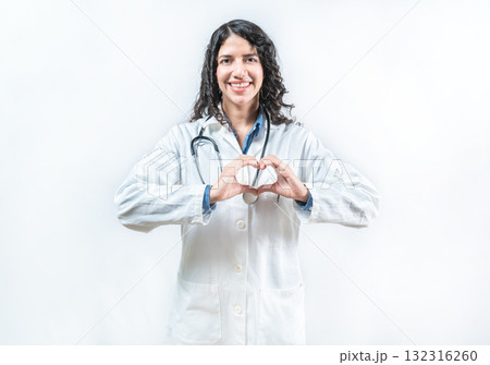 Smiling female doctor making heart shape isolated. Friendly female doctor gesturing heart isolated Smiling female doctor making heart shape isolated. Friendly female doctor gesturing heart isolated 132316260