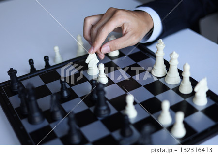 Businessman playing chess game; business strategy, leadership and management concept. Businessman playing chess game; business strategy, leadership and management concept. 132316413
