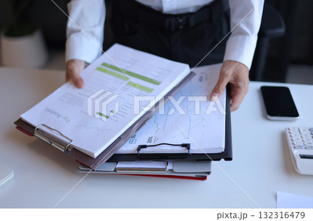 Businessman working in office reading documents analyze data for project planning. Businessman working in office reading documents analyze data for project planning. 132316479