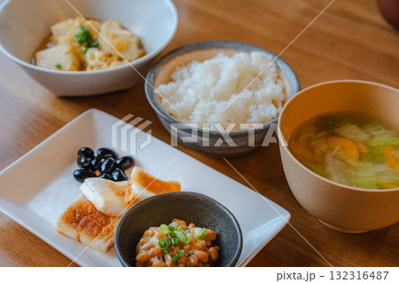 納豆や焼き餅、黒豆、卵とじが並ぶ家庭的で健康的な和朝食 132316487