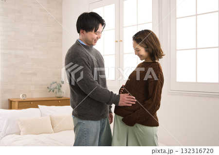 窓際に立つ若い夫婦 妊婦さん 窓際に立つ若い夫婦 妊婦さん 132316720