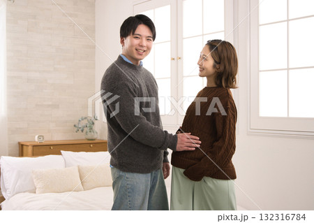 窓際に立つ若い夫婦　妊婦さん 132316784