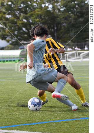 ドリブルするサッカー選手 132317071