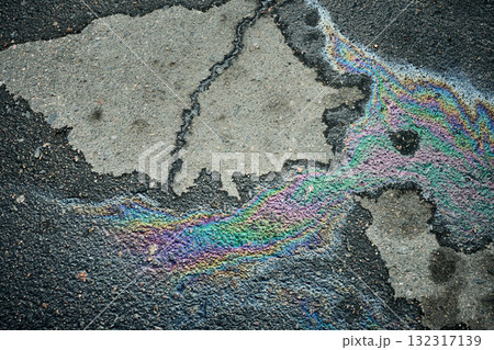 Colorful Oil Slick on Asphalt Surface Creates Vibrant Patterns in Urban Environment During Daylight Hours. Colorful Oil Slick on Asphalt Surface Creates Vibrant Patterns in Urban Environment During Daylight Hours. 132317139
