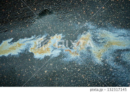 Polluting oil slick spreading on wet asphalt pavement Polluting oil slick spreading on wet asphalt pavement 132317145