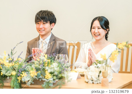 結婚式の披露宴の高砂席で挨拶を聞く新郎新婦 132319679