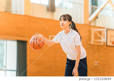 体育館でバスケットをする体操着姿の女子中学生・女子高生 体育館でバスケットをする体操着姿の女子中学生・女子高生 132320694