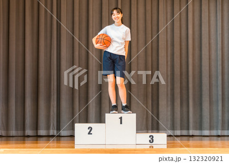 体育館のステージで表彰台に乗る体操着姿の小学生,中学生,高校生の女の子 132320921