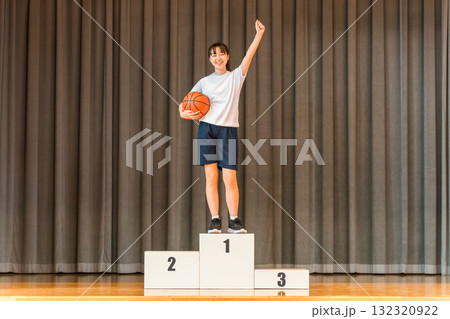 体育館のステージで表彰台に乗る体操着姿の小学生,中学生,高校生の女の子 132320922