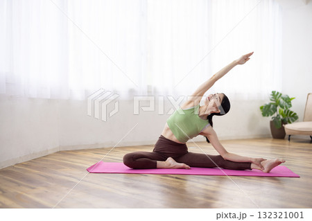 ヨガマットの上でヨガのポーズをするミドル女性 132321001