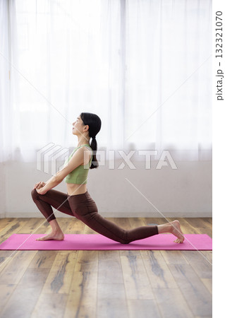 ヨガマットの上でヨガのポーズをするミドル女性 132321070