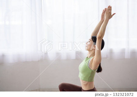 ヨガマットの上でヨガのポーズをするミドル女性 132321072