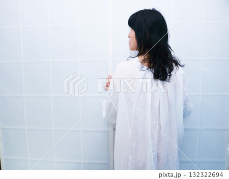 ロングシャツ着て障子の前に立つ女性の後ろ姿 132322694