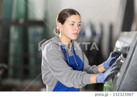 Young woman operates control panel in factory 132323067