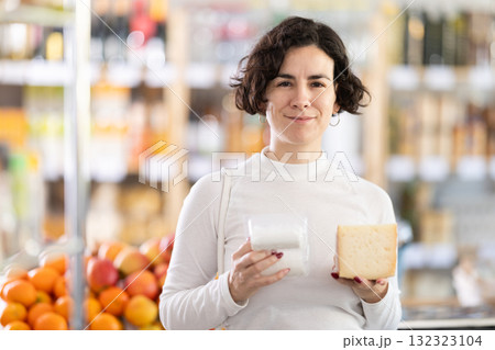 In store, woman near counter are looking at varieties of cheese 132323104