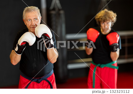 Senior man preparing for sparring in boxing gloves 132323112