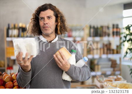 Adult man choosing dairy products in grocery store Adult man choosing dairy products in grocery store 132323178