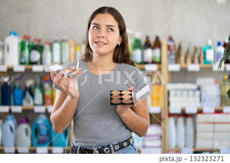 Interested young woman picking beauty products in store Interested young woman picking beauty products in store 132323271