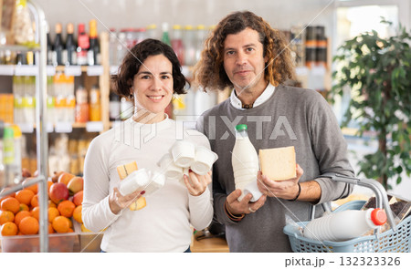 Family with various dairy products in her hands continues to make choice in grocery department of supermarket 132323326
