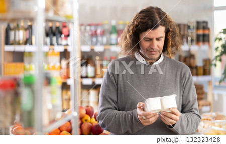Adult man choosing yogurt in grocery store 132323428
