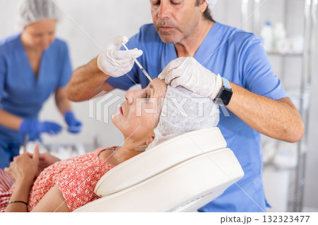 Senior woman undergoing botulinum injections at aesthetic medicine clinic Senior woman undergoing botulinum injections at aesthetic medicine clinic 132323477