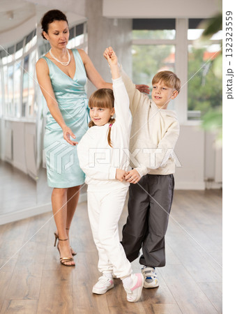 Teacher rearrange dancers pose during pair ballroom dancing lesson. 132323559