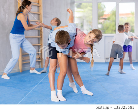 Boys and girls in gym perform basic elements of krav maga self-defense system. 132323583