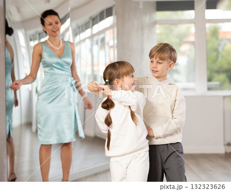 Tween girl and boy practicing waltz in dance hall with female mentor Tween girl and boy practicing waltz in dance hall with female mentor 132323626