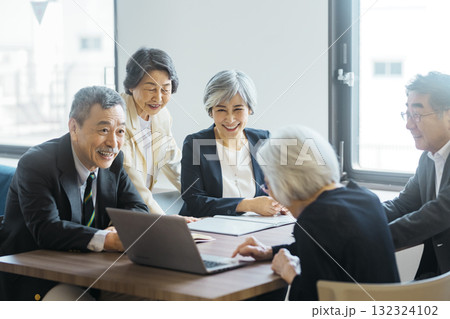 ノートパソコンを囲んで会議をするシニアチーム 132324102